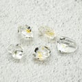 Herkimer gemstones with oil inside put on a white surface