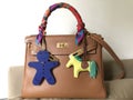 Hermes kelly bag size 28 epsom leather in gold color with silk twilly scarf petit h and rodeo bag charm