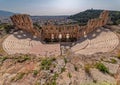 Herodion ancient open theater under Acropolis and Athens panoramic view under intense sun.