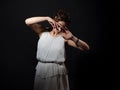 heroine of an ancient tragedy in grief and loss. A young woman in a white tunic