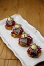 Herring canapes with pickled onions and baked potatoes. Appetizer on a platter close-up