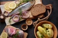 Herring fish  on wooden board  with pepper, herbs, red onion and lemon on black  background. Royalty Free Stock Photo