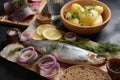 Herring fish  on wooden board  with pepper, herbs, red onion and lemon on black  background Royalty Free Stock Photo