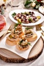 Herring and pickle rolls and other appetizers on Christmas table
