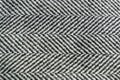 Herringbone tweed wool fabric texture background closeup. Natural organic wool cloth with classic pattern