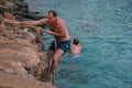 09.20.2008, Hersonissos, Crete, Greece. A man climbing on the rock to jump into the water.