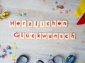 Herzlichen GlÃÂ¼ckwunsch congratulations lettering with party supplies on wooden background Royalty Free Stock Photo