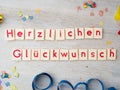 Herzlichen GlÃÂ¼ckwunsch congratulations lettering with party supplies on wooden background Royalty Free Stock Photo
