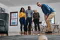 Hes aiming for success. Full length shot of a businessman playing golf in his office with his colleagues rooting for him Royalty Free Stock Photo