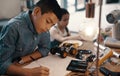 Hes already a great example to his younger sister. a handsome young boy doing his homework on robotics at home with his Royalty Free Stock Photo