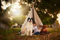 Hes best friend and babysitter all in one. a cute little girl playing outside a teepee with her dog. Royalty Free Stock Photo