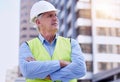 Hes building the future. a handsome mature male construction worker standing with his arms folded outside. Royalty Free Stock Photo