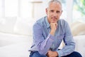 Hes confident and mature. Portrait of a smiling mature man sitting on a sofa in his living room. Royalty Free Stock Photo