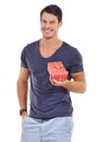 Hes cool and casual. Studio portrait of a handsome young man holding a small gift box isolated on white. Royalty Free Stock Photo