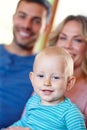 Hes the cutest little guy...Portrait of a happy young family sitting at home.