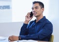 Hes an employee who knows how to deliver exceptional work. a young businessman talking on a cellphone in an office.