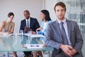 Hes a finance guru. Portrait of a young businessman with his colleagues having a meeting in the background. Royalty Free Stock Photo