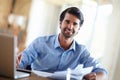 Hes a financial whizz. A handsome young businessman working on his laptop at his desk.