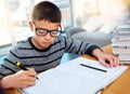 Hes going to change the world one day. a determined young boy doing his homework at home. Royalty Free Stock Photo