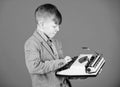 Hes going to write a composition. Smart child writer. Little writer typing on retro typewriter. Cute boy writer working
