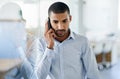 Hes got business on the line. a handsome young businessman talking on his cellphone in the office. Royalty Free Stock Photo