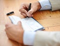 Hes got his expenses covered. Cropped closeup shot of a businessman signing cheques.