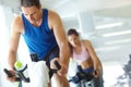 Hes got his eye on the prize. A man and woman exercising in spinning class at the gym. Royalty Free Stock Photo