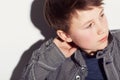 Hes got his own style. Young adolescent boy sitting against a white background and looking away. Royalty Free Stock Photo