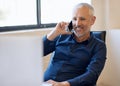 Hes got impeccable phone etiquette. a happy businessman answering his phone while working at his computer in the office. Royalty Free Stock Photo