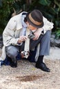 Hes got a keen investigative eye. Curious private investigator looking through a magnifying glass at the ground for Royalty Free Stock Photo