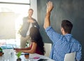 Hes got the right answer. a businessman raising his hand in an office meeting. Royalty Free Stock Photo