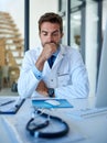 Hes got some tough decisions ahead. a young doctor looking stressed while working in his office.