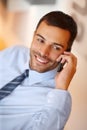 Hes great at client liaising. A handsome young businessman making use of his smartphone with a smile. Royalty Free Stock Photo