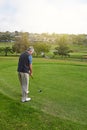 Hes on the green. Full length shot of a senior man lining up a put while enjoying a day playing golf. Royalty Free Stock Photo