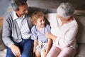 Hes handsome like his dad. Grandparents sitting on the couch with their grandson. Royalty Free Stock Photo