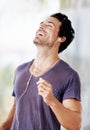 Hes a happy go lucky kinda guy. a handsome man laughing with his earphones in listening to music. Royalty Free Stock Photo