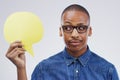 Hes having a peep at the comments. a handsome young man holding a speech bubble against a grey background. Royalty Free Stock Photo