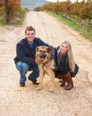 Hes like a child to them. Portrait of a young couple with their pet Alsatian on a wine farm. Royalty Free Stock Photo