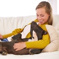 Hes the most loyal friend anyone could hope for. an attractive young woman petting her dog on the sofa.