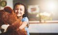 Hes my beary best friend. Portrait of a little girl holding her teddy bear at home.