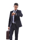 Hes never pressed for time. A handsome young businessman holding a briefcase and checking his watching against a white Royalty Free Stock Photo