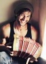 Hes not your convential musician. Handsome young man playing an accordian with a smile.
