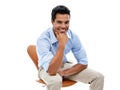 Hes one confident character. Studio shot of a handsome young man sitting in a studio isolated on white. Royalty Free Stock Photo