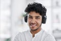 Hes one confident go getter. Portrait of a young businessman wearing headphones in an office.