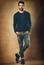 Hes one seriously good looking guy. Studio portrait of a handsome young man posing against a brown background.