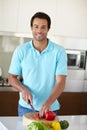 Hes a pro in the kitchen. Portrait of a handsome man chopping vegetables at a kitchen counter. Royalty Free Stock Photo