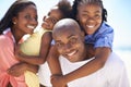 Hes a proud husband and father. Two parents giving their children a piggyback while on the beach. Royalty Free Stock Photo