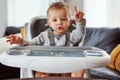 Hes quite the picky eater. a cute little baby boy sitting in his feeding chair. Royalty Free Stock Photo