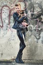 Hes a rockstars best friend. Full length portrait of an edgy young woman holding her small dog in an urban setting.