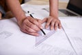 Hes a skilled draftsman. a draftsman drawing up building plans using a triangle.